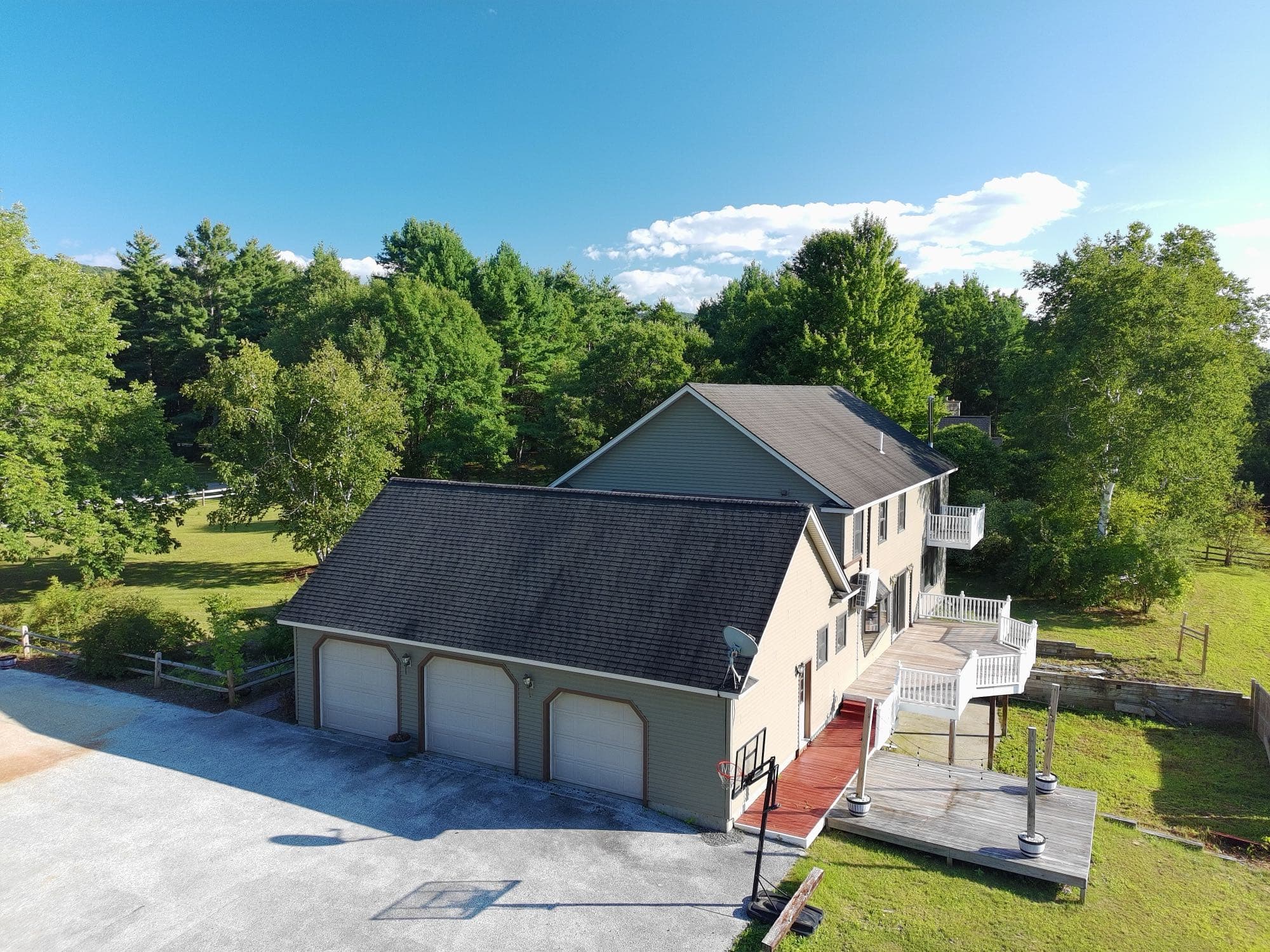 Aerial view of a Vermont property with attached three-car garage and rear deck