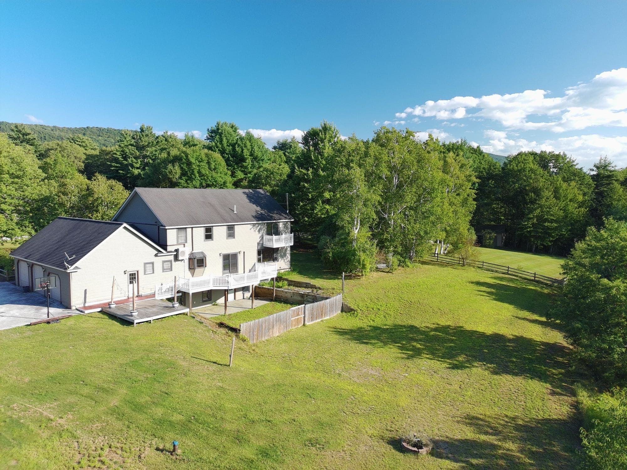Aerial view of a residential property and surrounding land